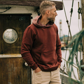 fit model on a boat wearing The Shackleton Hoodie in Russet