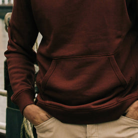fit model with hands in pockets wearing The Shackleton Hoodie in Russet