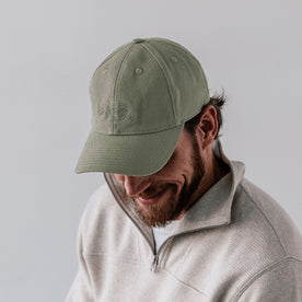 fit model showing off the front of The Canvas Cap in Olive Embroidered Bear