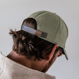 fit model showing off back strap on The Canvas Cap in Olive Embroidered Bear