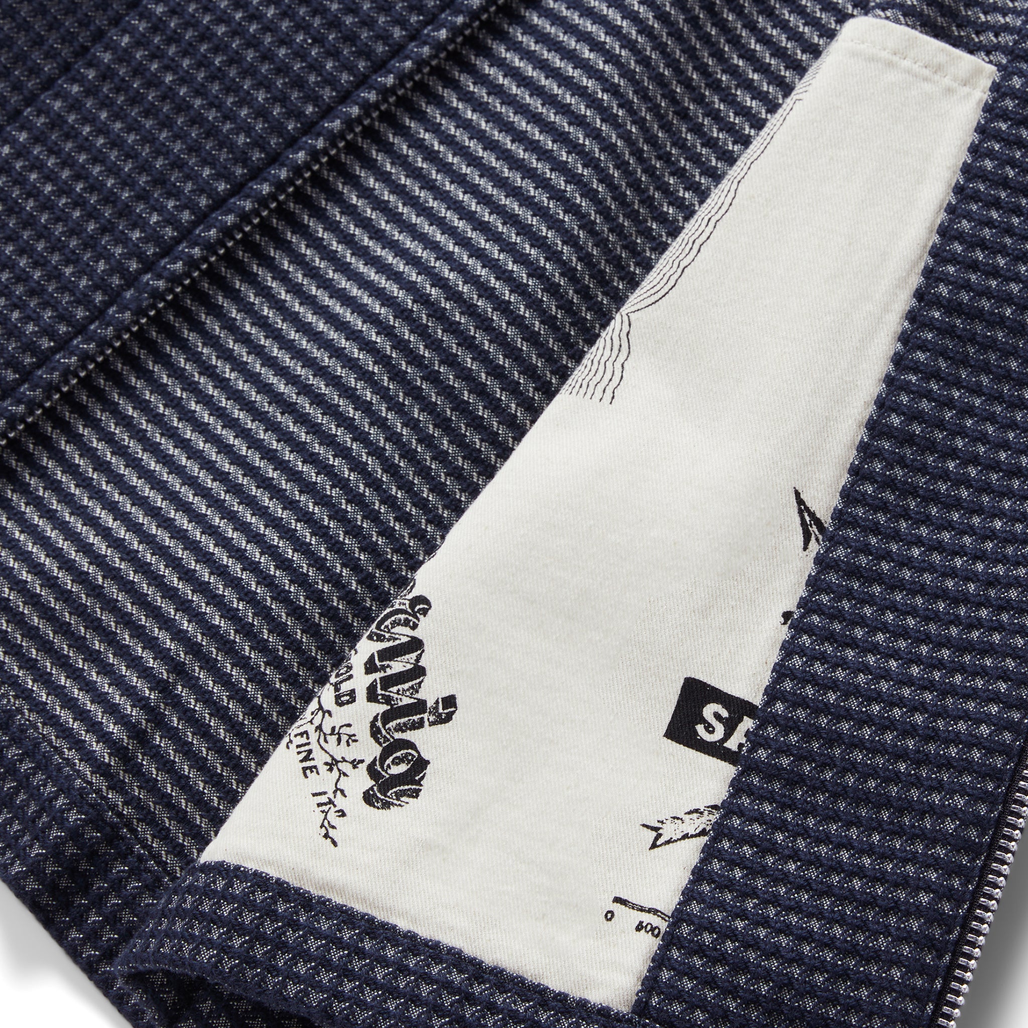 material shot of the interior map print detail on  The Cavern Jacket in Navy Dobby Grid, Outerwear by Taylor Stitch