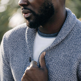 fit model adjusting the collar on The Crawford Sweater in Blue Melange