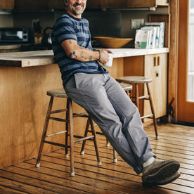 fit model sitting on a stool in The Democratic Foundation Pant in Organic Steeple Grey