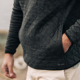 fit model with his hand in the side pocket of The Fall Line Pullover in Coal Heather