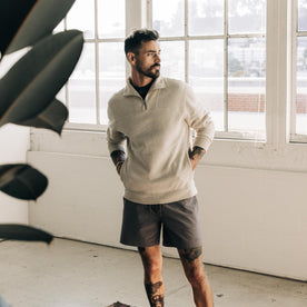 fit model with his hands in his pockets wearing The Horizon Pullover in Oat Heather
