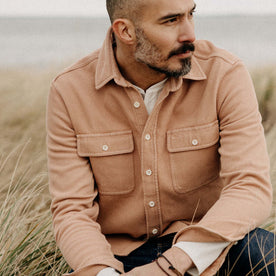 fit model sitting on the ground in The Ledge Shirt in Dusty Coral Twill
