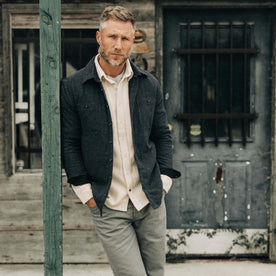 fit model leaning against a pole wearing The Lined Utility Shirt in Charcoal Donegal