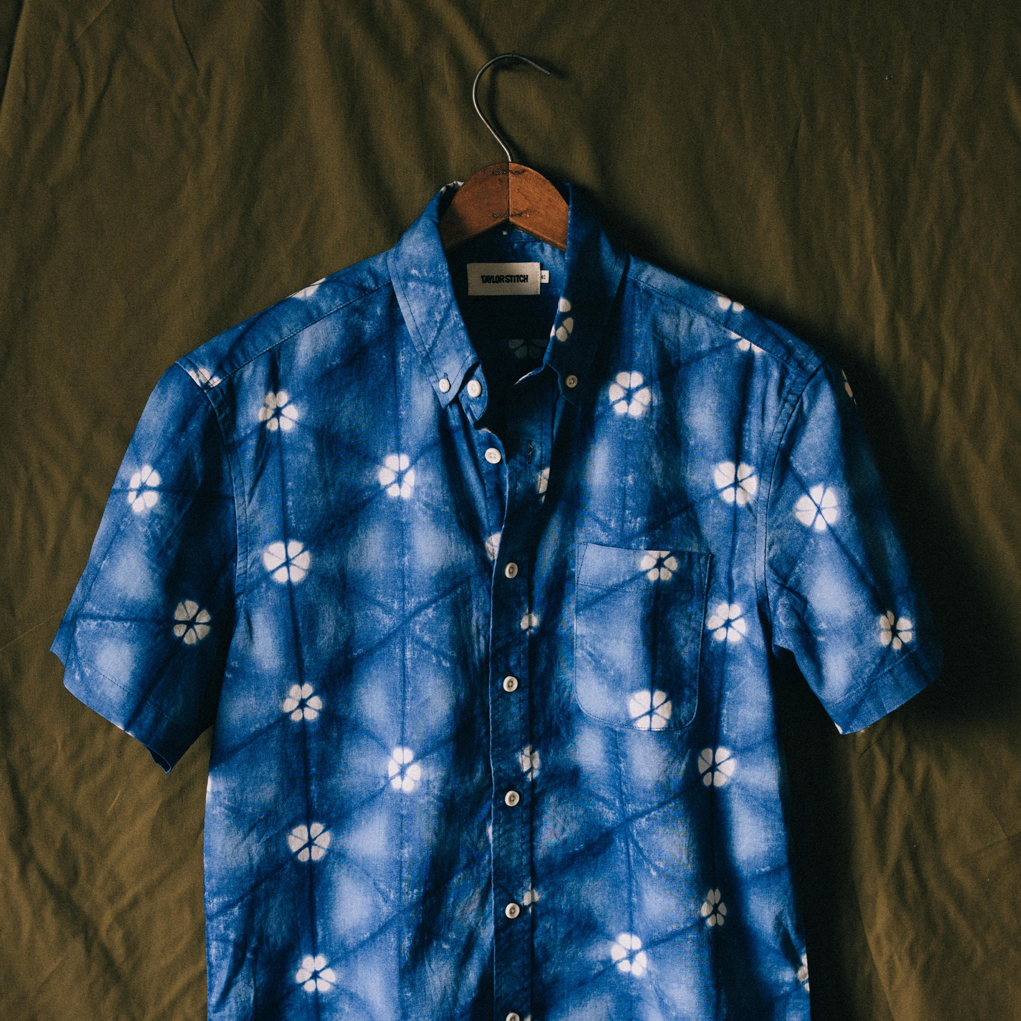 The Short Sleeve Jack in Deep Navy Floral on a green background, Wovens by Taylor Stitch