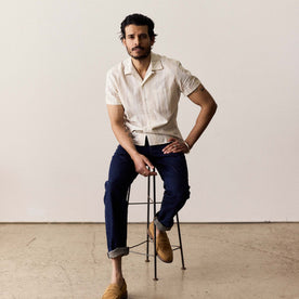 fit model sitting wearing The Short Sleeve Hawthorne in Fog Stripe, Wovens by Taylor Stitch