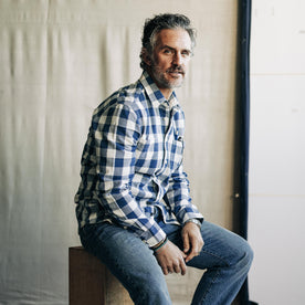 fit model sitting wearing The Utility Shirt in Sun Bleached Indigo Check