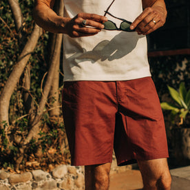 fit model wearing The Adventure Short in Rust, holding sunglasses