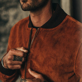 fit model wearing The Bomber Jacket in Whiskey Suede, cropped shot of chest zipping up jacket