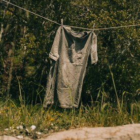 outdoor material shot of The Botanical Dye Tee in Moss, hanging on clothes line