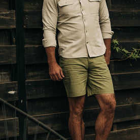 fit model wearing The Camp Short in Olive Herringbone, against wall