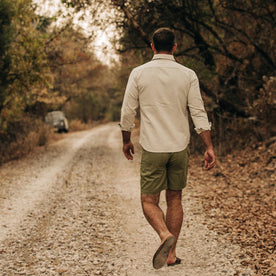 fit model wearing The Camp Short in Olive Herringbone, walking away from camera