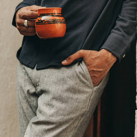 fit model wearing The Easy Pant in Navy Herringbone, hand in pocket, holding mug