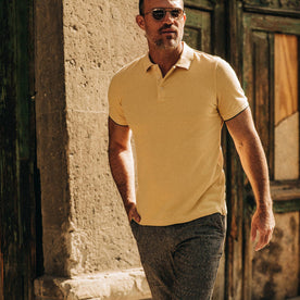 fit model wearing The Pique Polo in Straw, hand in pocket, walking