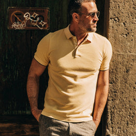 fit model wearing The Pique Polo in Straw, looking right