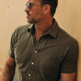fit model wearing The Short Sleeve California in Olive Pique, cropped, looking left, chest shot