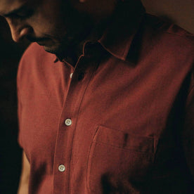 fit model wearing The Short Sleeve California in Rust Pique, up close shot of chest, looking down
