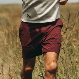 fit model wearing The Traverse Short in Wine, walking i field