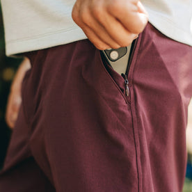 fit model wearing The Traverse Short in Wine, putting phone in pocket