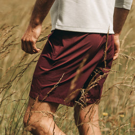 fit model wearing The Traverse Short in Wine, side profile in field