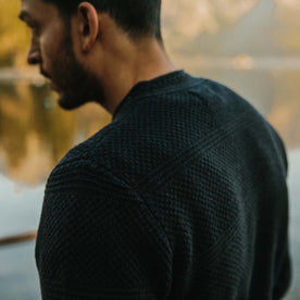 fit model in front of a lake showing The Ventana Sweater in Navy from the back
