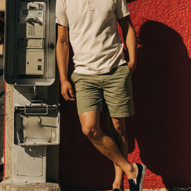 fit model standing by a payphone in The Foundation Short in Olive Twill