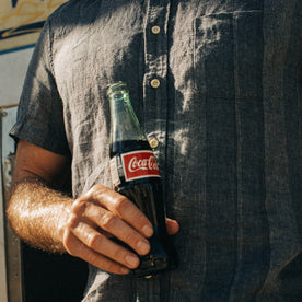 fit model holding a Coca-Cola wearing The Short Sleeve California in Dusk Stripe