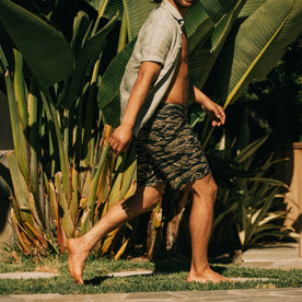 fit model walking wearing The Adventure Short in Tiger Camo