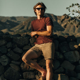fit model posting against a stone wall in The Cotton Hemp Tee in Rust and Navy Stripe