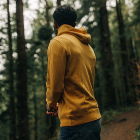fit model walking in the woods in The Fillmore Hoodie in Canary