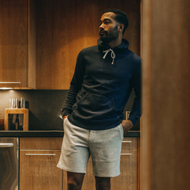 fit model wearing The Fillmore Hoodie in Dark Navy in his kitchen