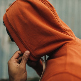 fit model adjusting the hood on The Fillmore Hoodie in Rust