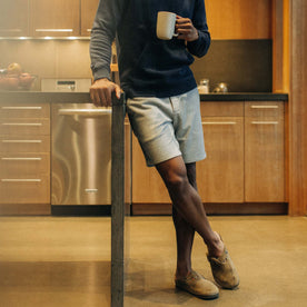 fit model leaning against a countertop in The Fillmore Short in Heather Grey