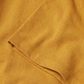 material shot of the sleeves on The Heavy Bag Tee in Gold