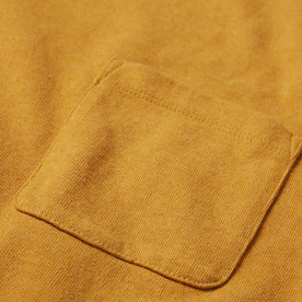 material shot of the chest pocket on The Heavy Bag Tee in Gold