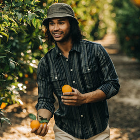 fit model holding oranges in The Ledge Shirt in Ocean Stripe