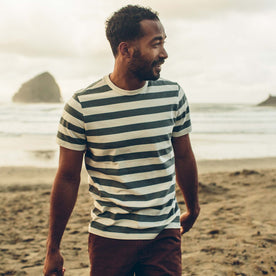 fit model wearing The Organic Cotton Tee in Natural and Ocean Stripe by the beach