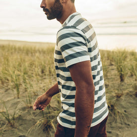 fit model walking on the beach in The Organic Cotton Tee in Natural and Ocean Stripe