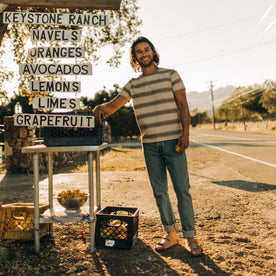 fit model standing by a fruit stand in The Organic Cotton Tee in Seagrass Stripe