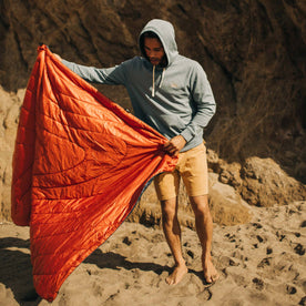 fit model laying out The Original Puffy Blanket in Navy Aloha