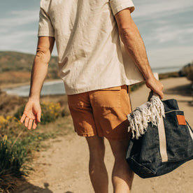 fit model walking down a sandy path in The Trail Short in Apricot Micro Cord