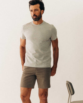 fit model posing next to a chair wearing The Organic Cotton Tee in Heather Grey, Knits by Taylor Stitch
