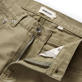 material shot of the button fly undone on The Slim All Day Pant in Arid Eucalyptus Canvas