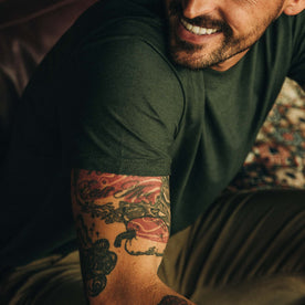 Close up of shoulder of fit model while wearing tee