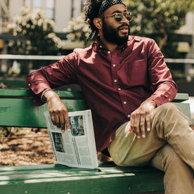 fit model wearing The Jack in Burgundy Oxford, holding newspaper