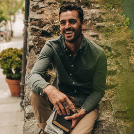 fit model wearing The Jack in Moss Cord, holding some books, laughing