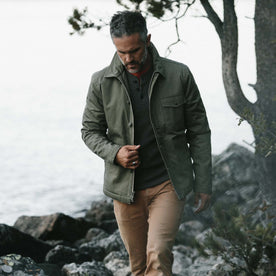 fit model wearing The Lined Watts Jacket in Olive in front of a lake